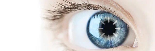 Das Bild zeigt ein Auge mit blauer Augenfarbe auf dem ein Ladesymbol zu sehen ist