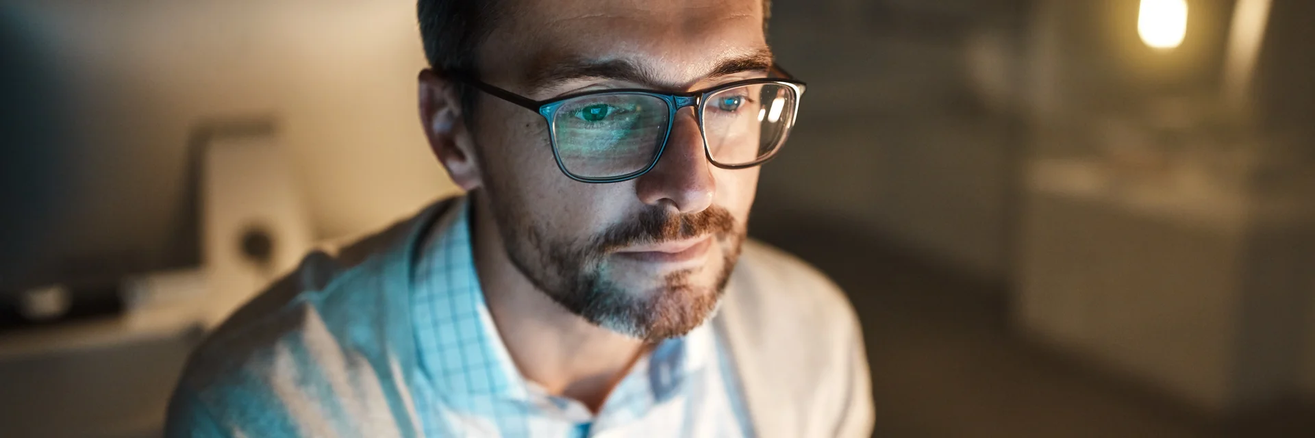 Ein Mann mit Brille und Bart sitzt vor einem Bildschirm