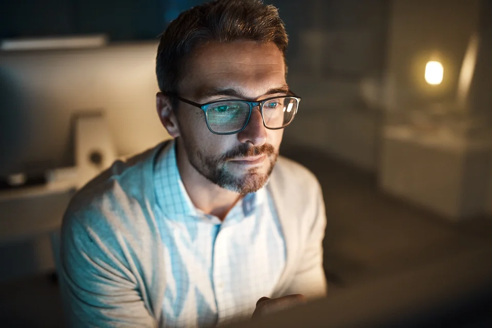 Ein Mann mit Brille und Bart sitzt vor einem Bildschirm